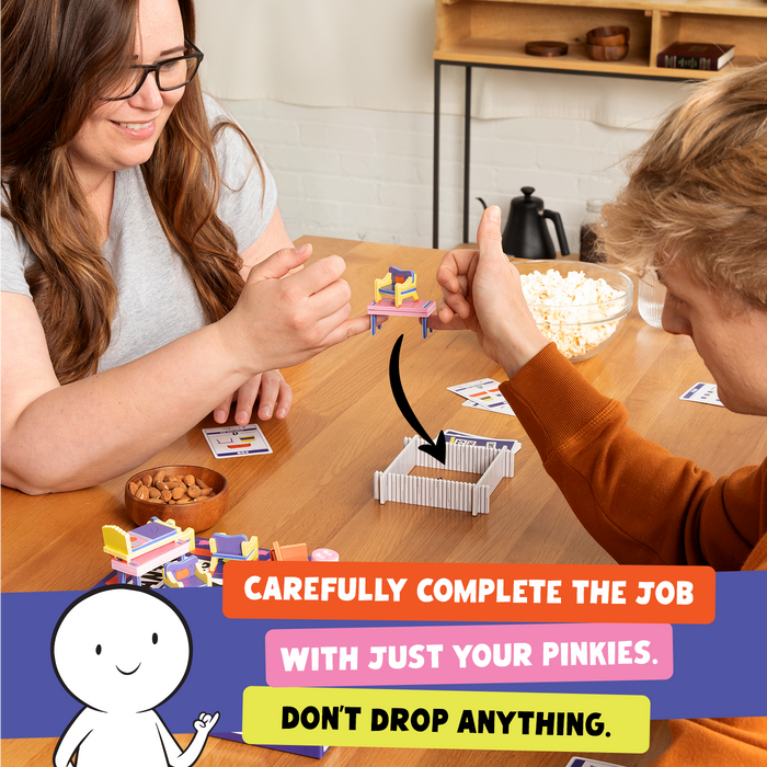 Two people moving tiny furniture with their pinkies during play