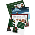 Four adult-humor holiday greeting cards fanned out beside a decorated Christmas tree