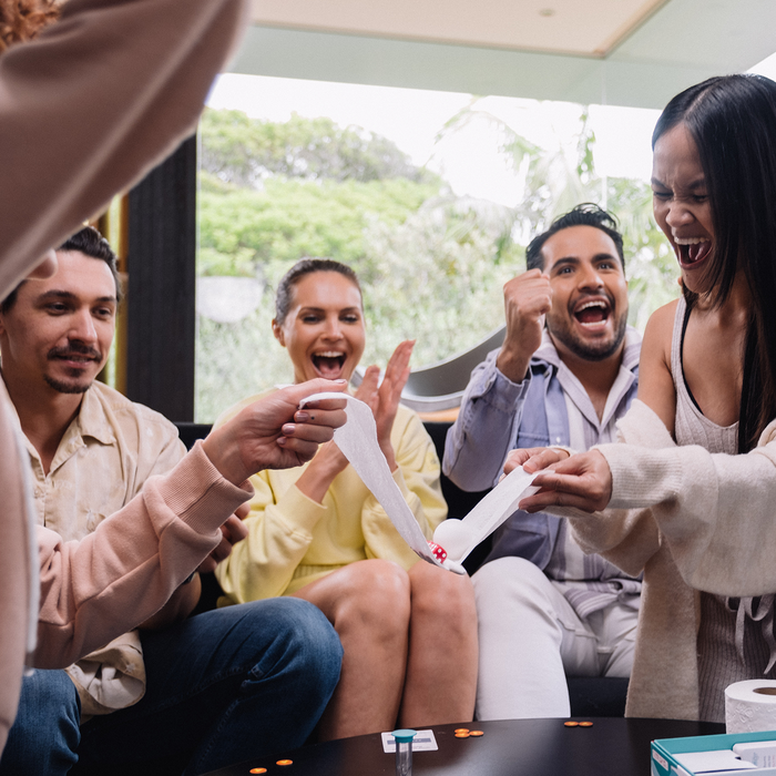Friends laughing and playing Without Fail at a party