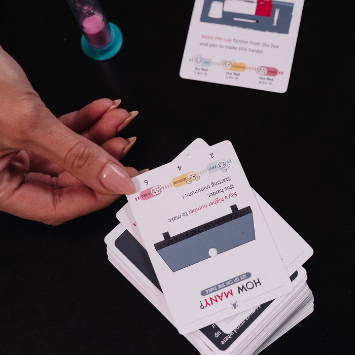 Hands holding cards during a game of Without Fail